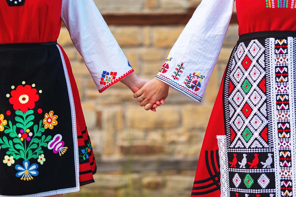 Дівчата у традиційних болгарських етнічних костюмах із фольклорною вишивкою