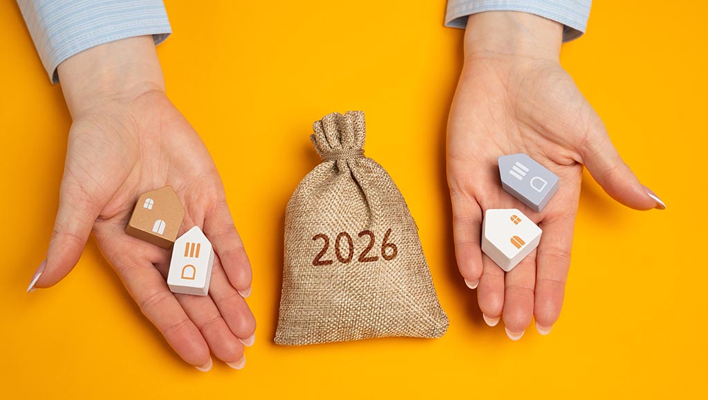 Руки тримають макети будинків і мішок з грошима, відображаючи фінансові аспекти купівлі нерухомості в Болгарії